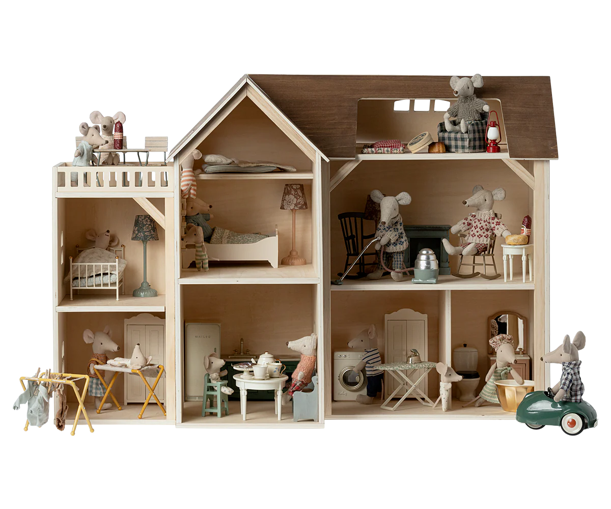 Wooden dollhouse with detailed interior and furniture on a white background