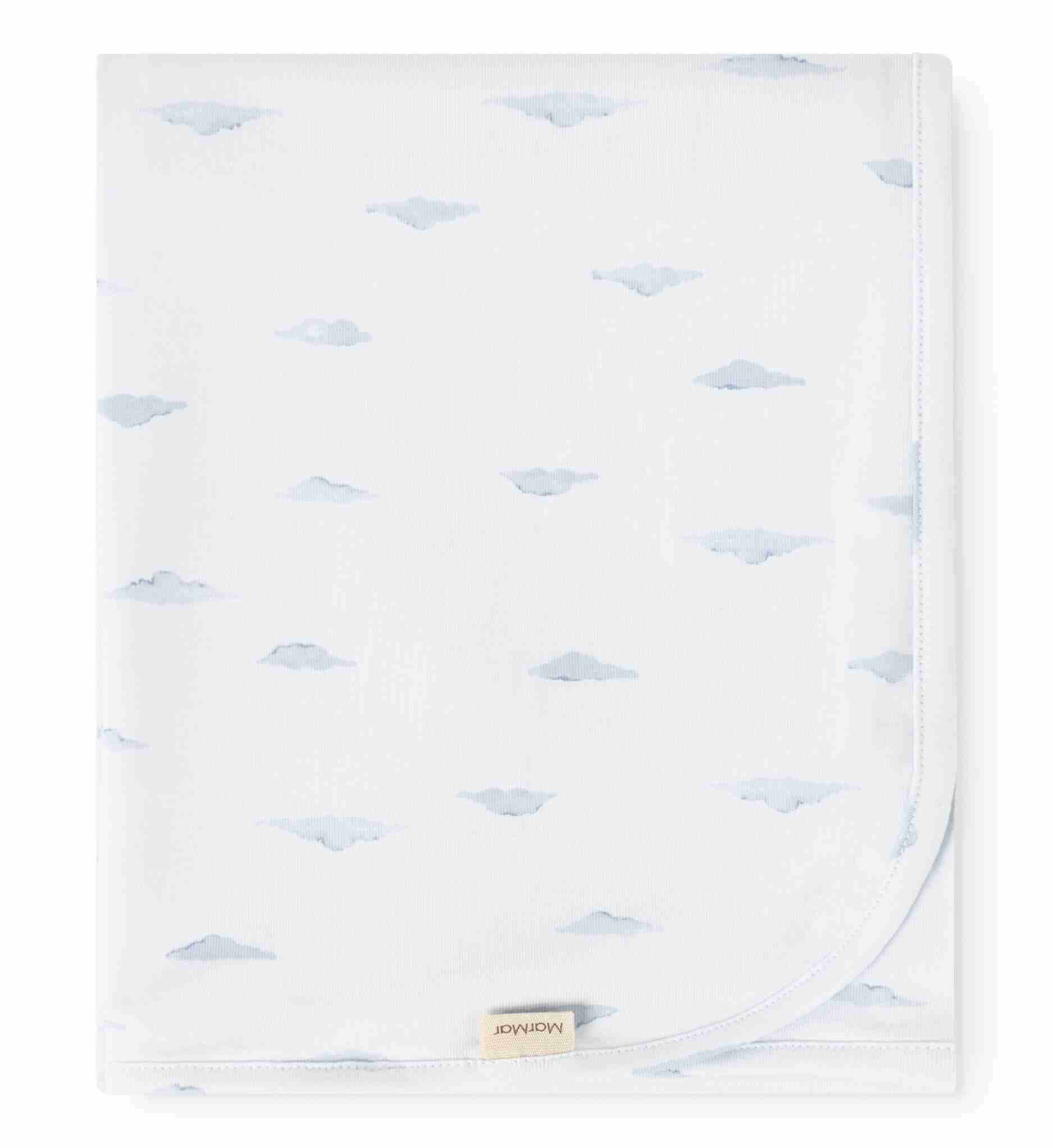 White blanket with blue cloud pattern and a visible brand label on a white background