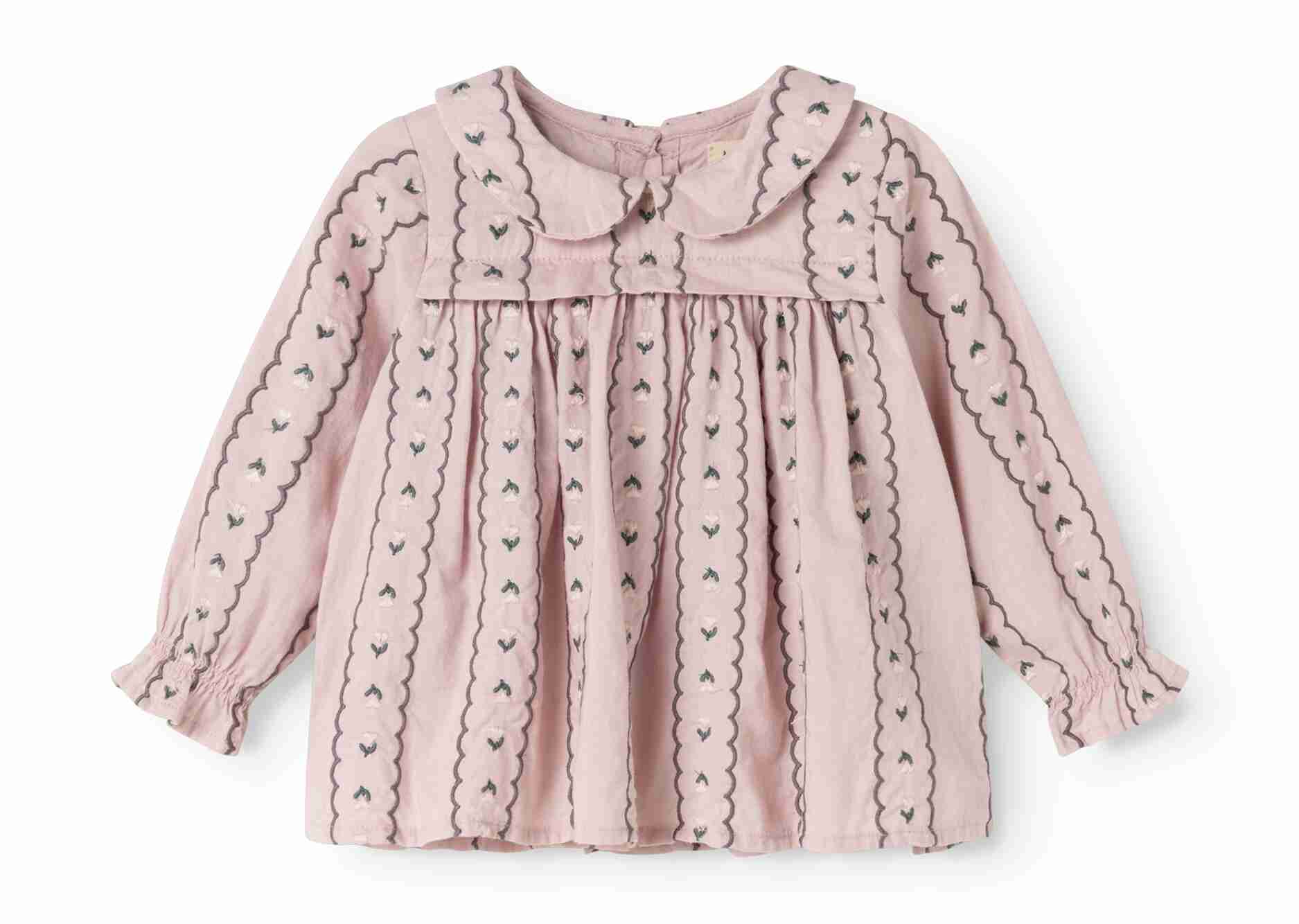 A light pink long-sleeve baby blouse with a Peter Pan collar, featuring vertical embroidered stripes with small heart motifs and scalloped edges.