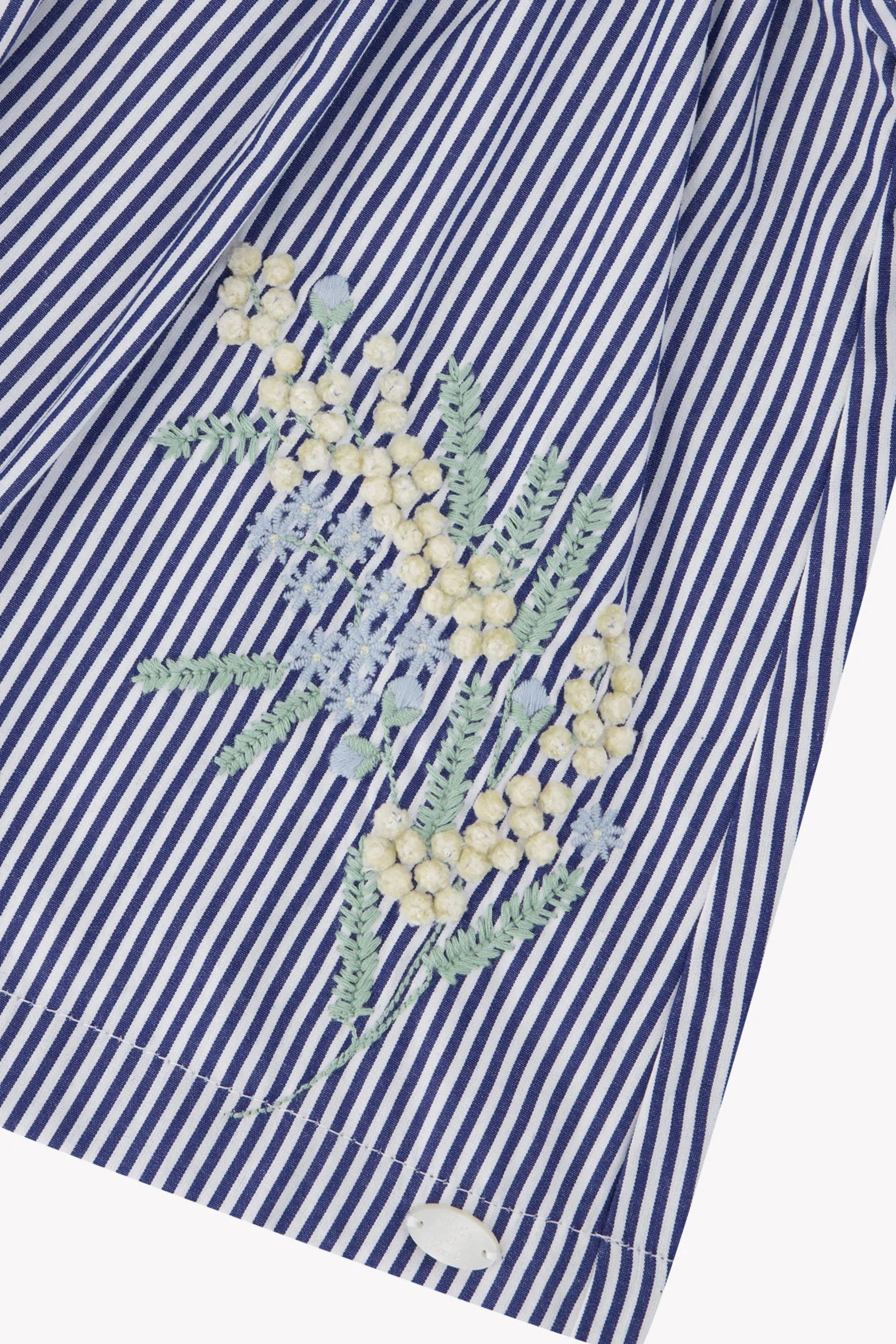 Blue and white striped shirt with floral embroidery on a white background