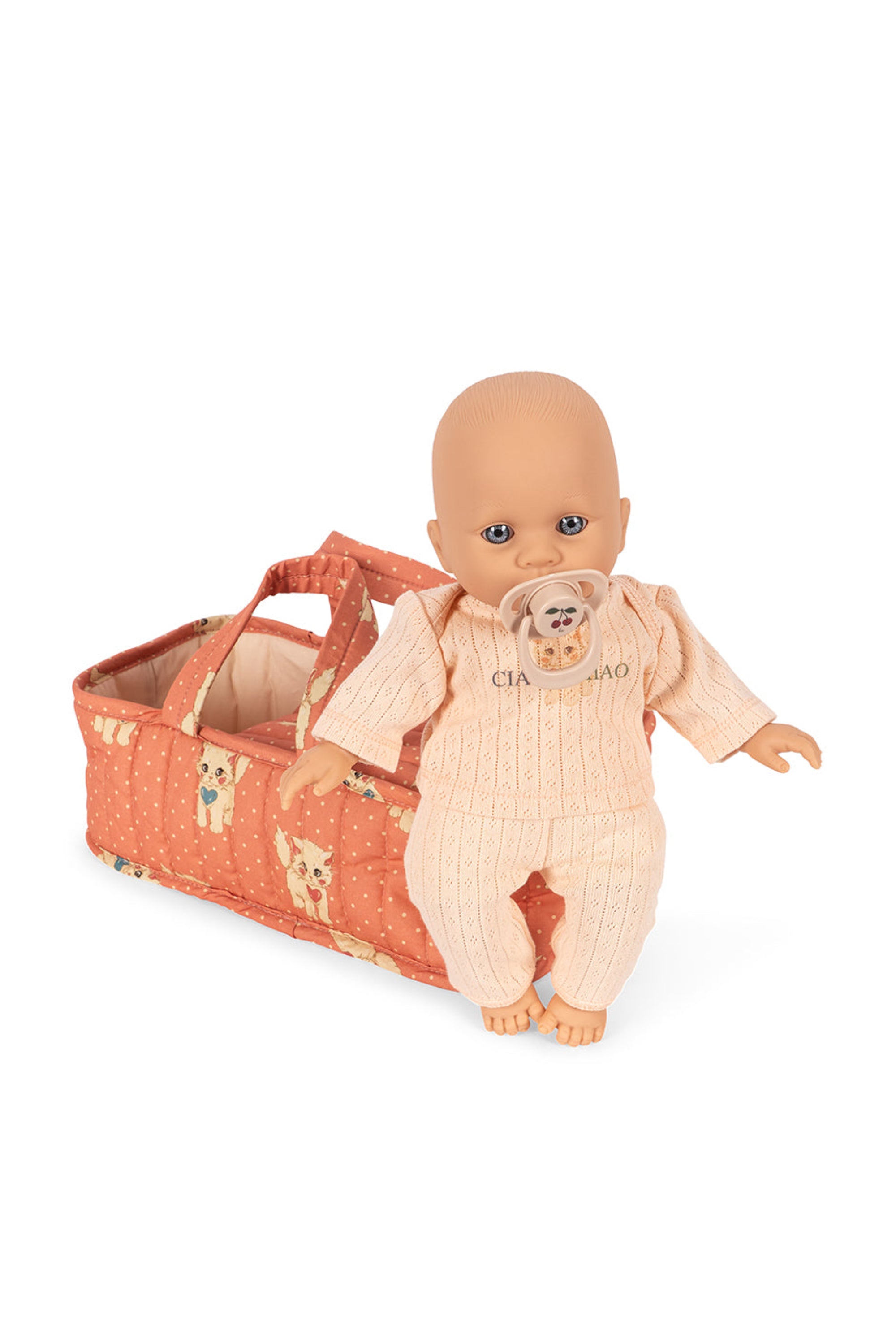 Baby doll in a pink outfit with a matching crib on a white background