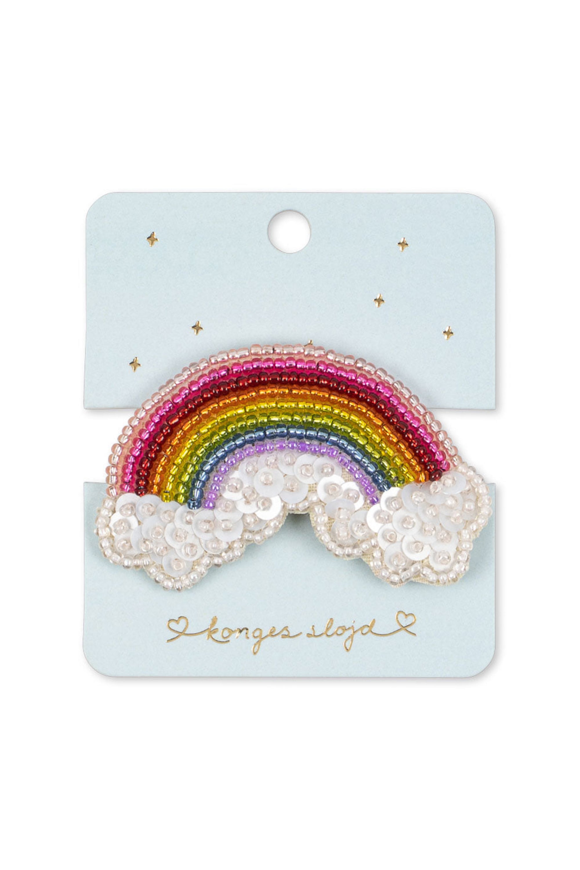 A rainbow patch with white cloud elements, decorated with colorful sequins and white pearls, mounted on a light blue backing card with gold stars and the brand name 'Longer and Longer'.